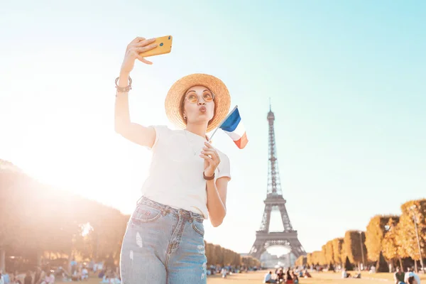 Счастливая азиатка делает селфи на смартфоне на фоне Эйфелевой башни. Концепция путешествий и качества изображений — стоковое фото