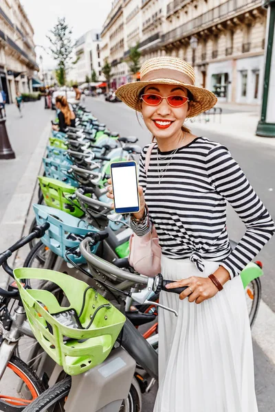 Young Asian girl unlock bike using app on smartphone. Sharing bicycle and ecology concept