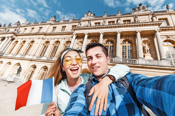 Para zakochany, Azjatycka dziewczyna i Europejski człowiek ogarnąć i zrobić selfie na tle Pałacu Królewskiego w Wersalu we Francji. Podróże i miesiąc miodowy — Zdjęcie stockowe
