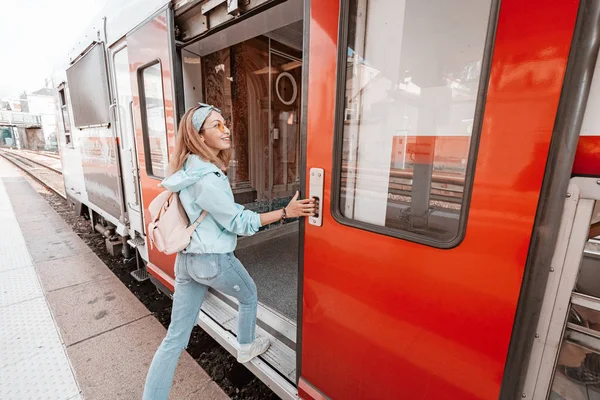 Asyalı bir kadın trenin vagonuna giriyor. Demiryolu taşımacılığı konsepti — Stok fotoğraf