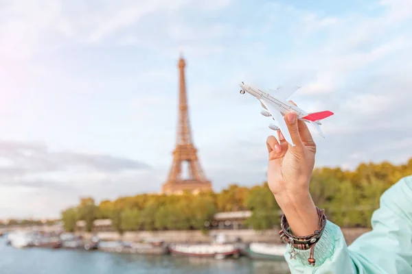 Chica jugando con un avión de juguete en el fondo de la torre Eiffel. Concepto de viajes aéreos y turismo — Foto de Stock