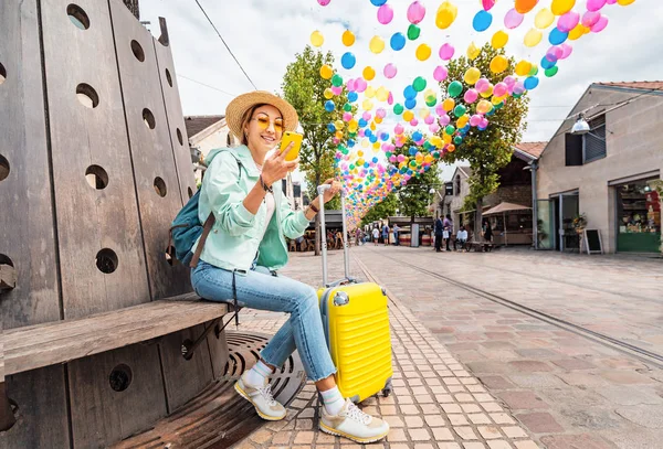 Mujer viajera con maleta amarilla en la hermosa calle decorada en París con globos — Foto de Stock