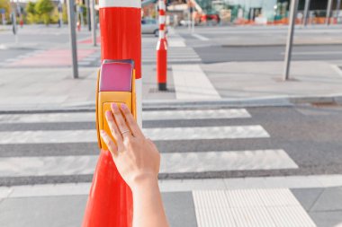 Kız trafik lambasındaki düğmeye basarak yeşile döner ve güvenli bir şekilde karşıya geçer.