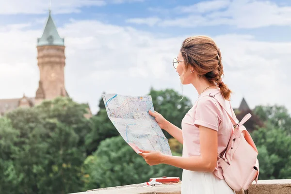 Счастливая азиатская девушка путешественник читает карту и ищет знаменитые достопримечательности в районе Люксембурга в Европе — стоковое фото