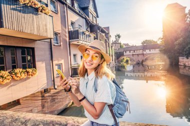 Eski Nurnberg şehri ve Pegnitz Nehri 'nin fotoğrafını çeken mutlu Asyalı kadın turist. Almanya konseptinde seyahat blogcusu
