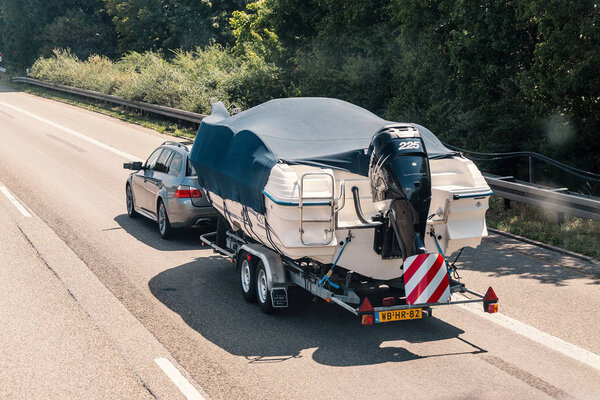 04 August 2019, Nuremberg, Germany: Car transport a big boat at highway road