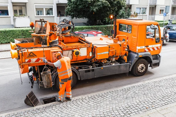 06 augusti 2019, Munchen, Tyskland: Arbetstagare i stadens allmännyttiga tjänst rensar dagvattenavlopp från igensättning. — Stockfoto