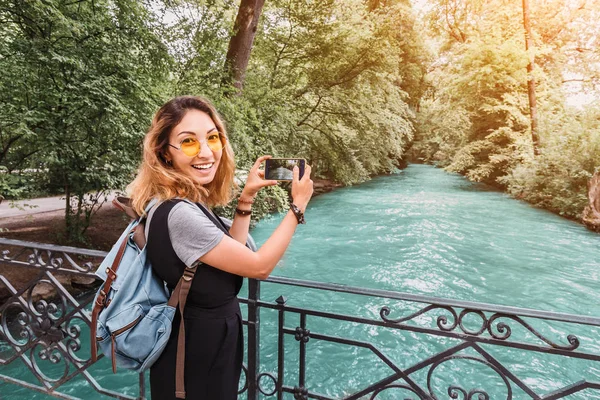 Asiatin macht Foto vom Gebirgsfluss auf ihrem Smartphone. Reiseblogger-Konzept — Stockfoto