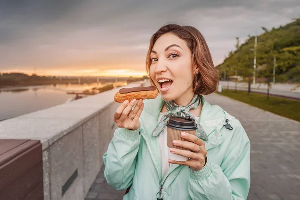 Азиатская Счастливая Девушка Ест Свежий Французский Десерт Eclair Пьет Кофе — стоковое фото