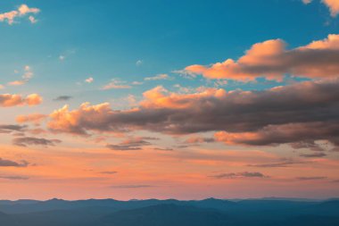 Bulutlu gün batımı gökyüzü ve güneşten gelen kırmızı yansımalar. Parlak renkli arkaplan