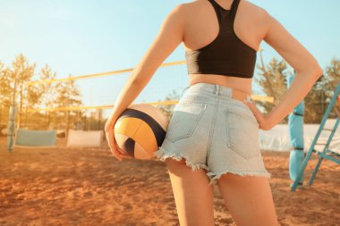 Kaslı ve atletik vücutlu, taş gibi kalçalı, plaj voleybolu oynayan fit bir kadın. Spor müsabakalarında spor ve kilo kaybı