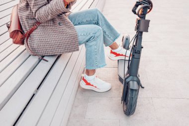 Modern elektrikli scooter 'ı olan bir kadın. Şehir Yaşam Tarzı ve Ulaşım Konsepti