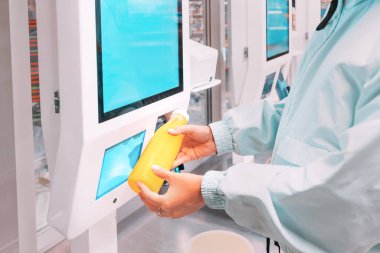 Mutlu genç müşteri kadın, modern bir süpermarkette, kuyrukta beklemekten kaçınmak için bir şişe portakal suyu alır ve parasını öder.