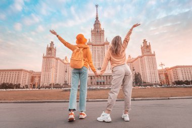 Moskova Üniversitesi 'nin arka planında iki kız arkadaş. Eğitim, turizm ve tatil konsepti