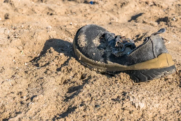 Trash schoen aangespoeld op het strand — Stockfoto