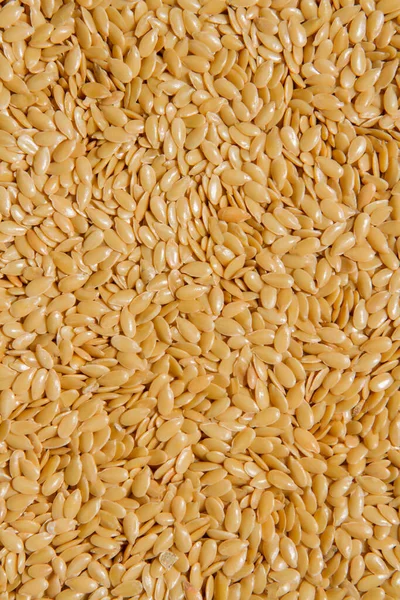 Close up.  Dry raw seeds gold colour linseed, flax seeds pattern background or texture.