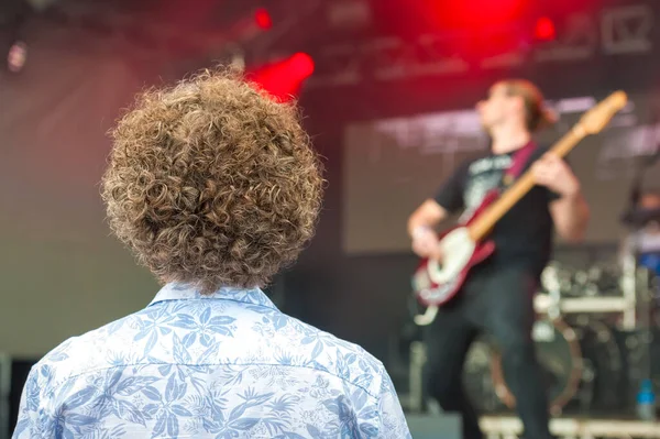 Młody Człowiek Bardzo Kręconymi Włosami Oglądający Zespół Rockowy Scenie — Zdjęcie stockowe