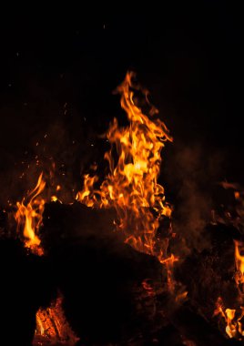 Yangın, şenlik ateşi, kamp ateşi. Gece şenlik ateşi alevleri. Siyah bir zemin üzerine alevler ateş