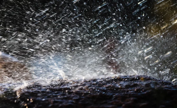 雨中淋湿的石头 雨水落到石头上 水在它们周围流动和飞溅 — 图库照片