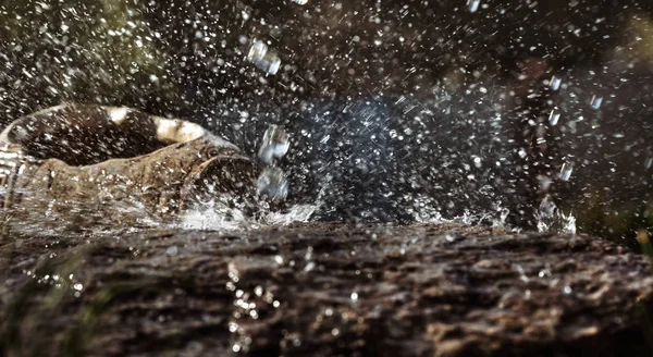 Taş ve dekoratif antika urn yağmurda ıslak. Yağmur su damlası taş'a düşüyor. Su akan ve onların etrafında sıçramasına.
