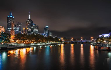 Melbourne, Avustralya - 11 Aralık 2014: Melbourne silüeti alacakaranlıkta Yarra Nehri boyunca. Başkenti ve en kalabalık şehri Victoria eyaletinde ve ikinci en kalabalık şehir Avustralya Melbourne olduğunu