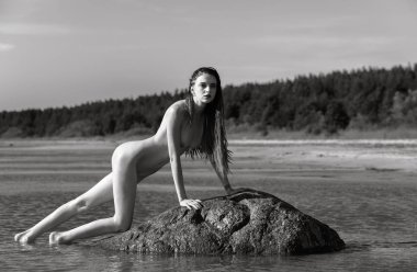Güzel kız açık havada doğanın keyfini siyah beyaz görüntü. Doğanın huzur olan dreadlocks taşın içinde deniz üzerinde çıplak kadın sahiptir