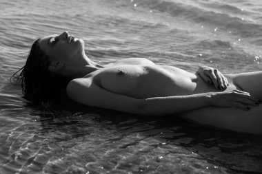 Güzel kız açık havada doğanın keyfini. Genç çıplak kadın scarlet dreadlocks ile denizin kıyısında sahiptir