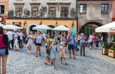 Lublin, Polonya - 27 Temmuz 2018: Kalabalık turist ve tatilciler Lublin eski şehir sokaklarında. Çocuklar ve yetişkinler dondurma yemek. Lublin Polonya'dokuzuncu büyük şehridir