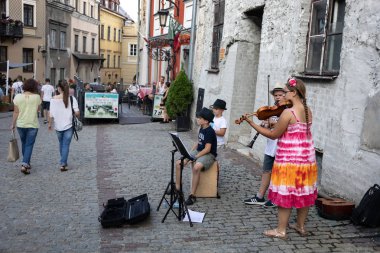 Lublin, Polonya - 27 Temmuz 2018: Kalabalık turist ve tatilciler Lublin eski şehir sokaklarında. Çocuk sokak müzisyenleri. Lublin Polonya'dokuzuncu büyük şehridir