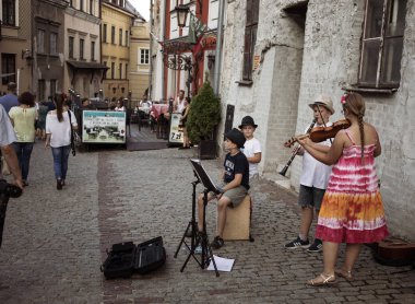Lublin, Polonya - 27 Temmuz 2018: Kalabalık turist ve tatilciler Lublin eski şehir sokaklarında. Çocuk sokak müzisyenleri. Lublin Polonya'dokuzuncu büyük şehridir