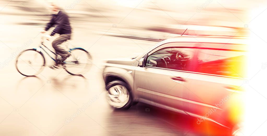 Road accident. Dangerous city traffic situation with a cyclist and cars in motion blur and color shift