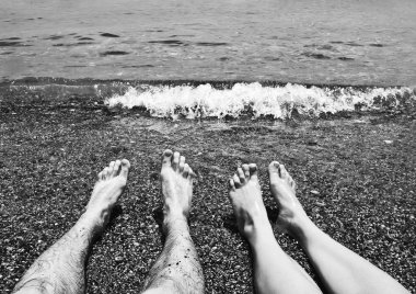Erkek ve kadın ayakları ve deniz kenarı siyah beyaz resim