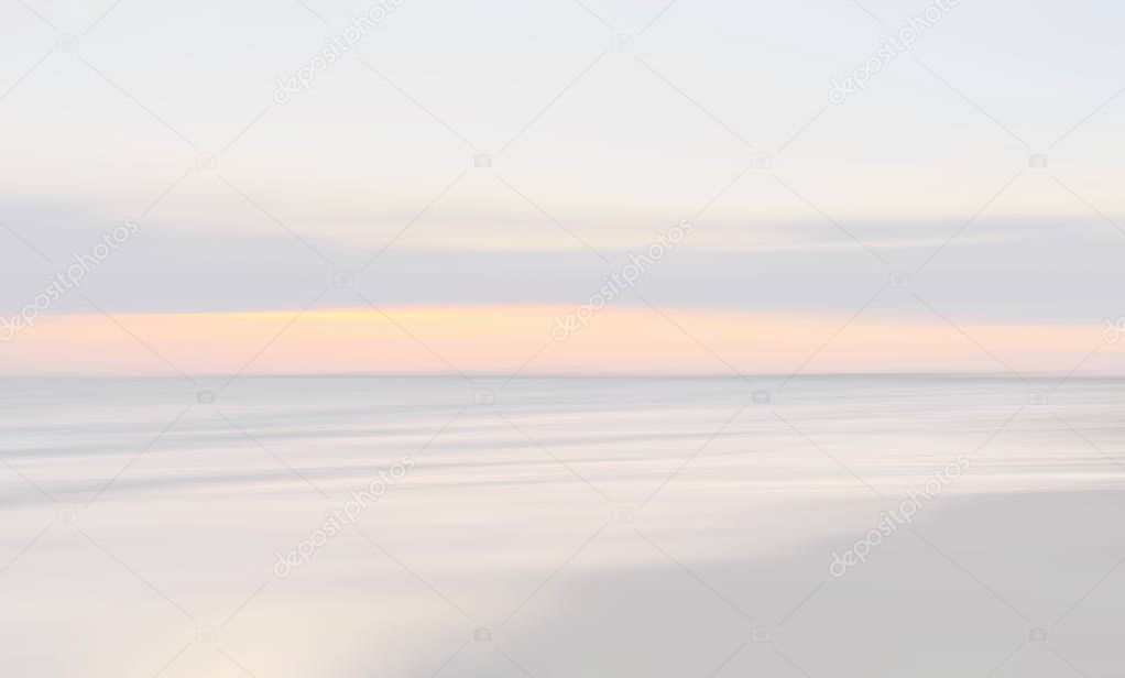 Abstract blurred sea landscape and cloudy sky background in light tonality with copy space