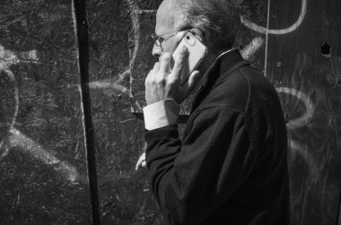New York, ABD - Eyl 24, 2018: Manhattan sokak sahne siyah beyaz görüntü. New York City sokaklarında Amerikalılar. Yaşlı adam bir cep telefonu ile