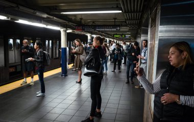 New York, ABD - Eylül 24, 2018: New York ve New Yorklu. New York City Metro. Onların tren bekliyorsun akıllı telefonlar ile yolcu