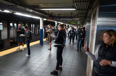 New York, ABD - Eylül 24, 2018: New York ve New Yorklu. New York City Metro. Onların tren bekliyorsun akıllı telefonlar ile yolcu