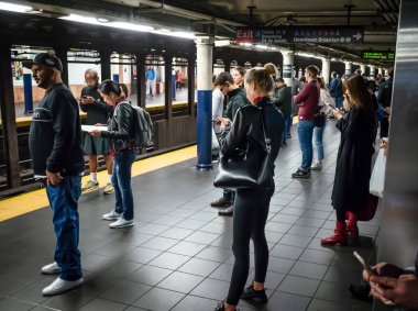 New York, ABD - Eylül 24, 2018: New York ve New Yorklu. New York City Metro. Onların tren bekliyorsun akıllı telefonlar ile yolcu