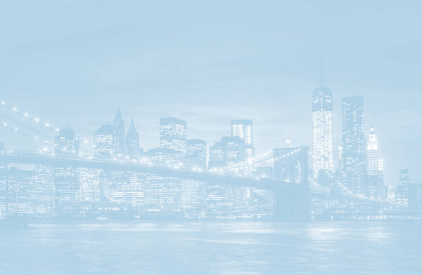 Light blue image of Brooklyn Bridge, East River and Manhattan with lights and reflections. New York City