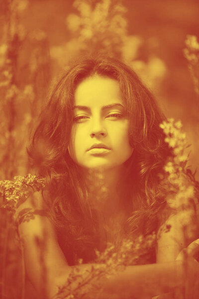 Duotone yellow and red image of young woman with wild flowers on background