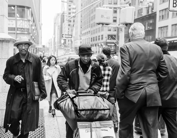 ニューヨークのマディソン アベニューのニューヨーク アメリカ合衆国 2016 黒と白のイメージ マンハッタンの通りの様子 彼らのビジネスについて行くふたりのものを積んだカートと浅黒い肌 — ストック写真