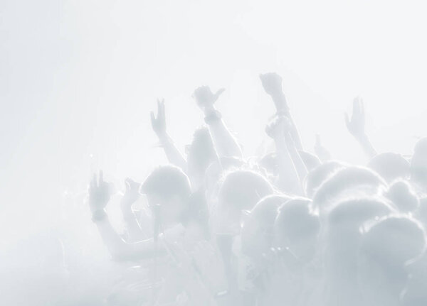 Crowd of spectators at a concert in light blue tonality. High key background with a people on an open playground at a concert. Abstract soft focus image with copy space