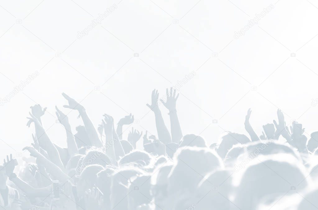 Crowd of spectators at a concert in light blue tonality. High key background with a people on an open playground at a concert. Abstract soft focus image with copy space