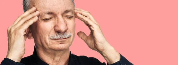 強い頭痛の種 老人は 彼の手と疲れた感じと頭痛で頭を触れます 医療コンセプト コピー スペースとピンクの背景に分離されて頭痛に苦しむ老人 — ストック写真