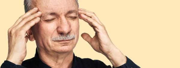 強い頭痛の種 老人は 彼の手と疲れた感じと頭痛で頭を触れます 医療コンセプト コピー スペースと黄色の背景に分離されて頭痛に苦しむ老人 — ストック写真