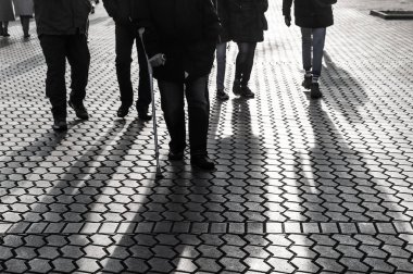 Yaşam tarzı kavramı. Işık ve gölge City. Büyük bir şehrin sokaklarında yürüyüş ve arka ışık tarafından insan siluetleri. Gölgeler akşam ışığında street yürüyüş insanların.