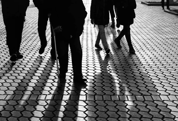 Life style concept. Light and shadows in city. Silhouettes of people walking the streets of a big city and lit by back light. Shadows of people walking street in evening light.