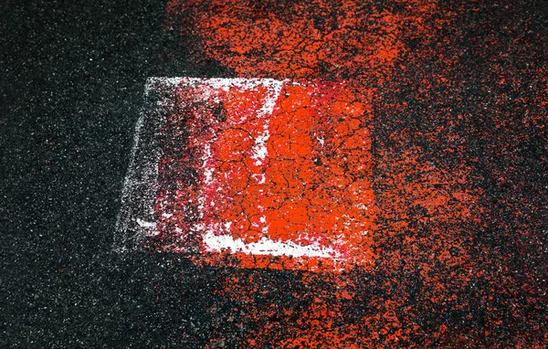 アスファルトの上の抽象的なカラフルな構成 アスファルトの背景に抽象的な記号 赤と白の水玉 古いひびの入ったアスファルト表面のパターンとアスファルト道路のテクスチャをクローズ アップ — ストック写真