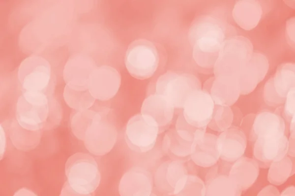 Holidays and design concept.  Abstract background. Image with blurred bokeh lights in trendy living coral color