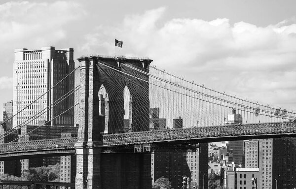 Black and white image of Brooklyn bridge and Manhattan from Brooklyn via East river