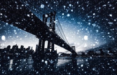 Manhattan siluetinin ve Manhattan Köprüsü, gece bir kar yağışı sırasında. 